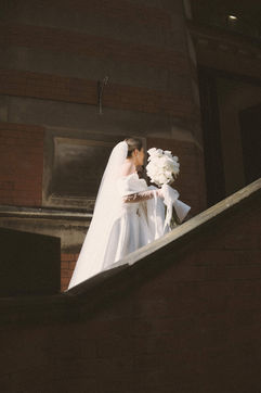 Georgia on the stairs at The Pumping House with her white bouquet