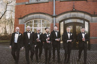 Groomsmen in black tuxedos outside The Pumping House in Ollerton