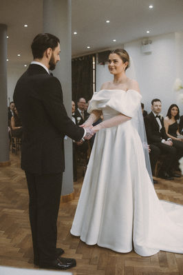 Georgia and Will hold hands during their wedding ceremony