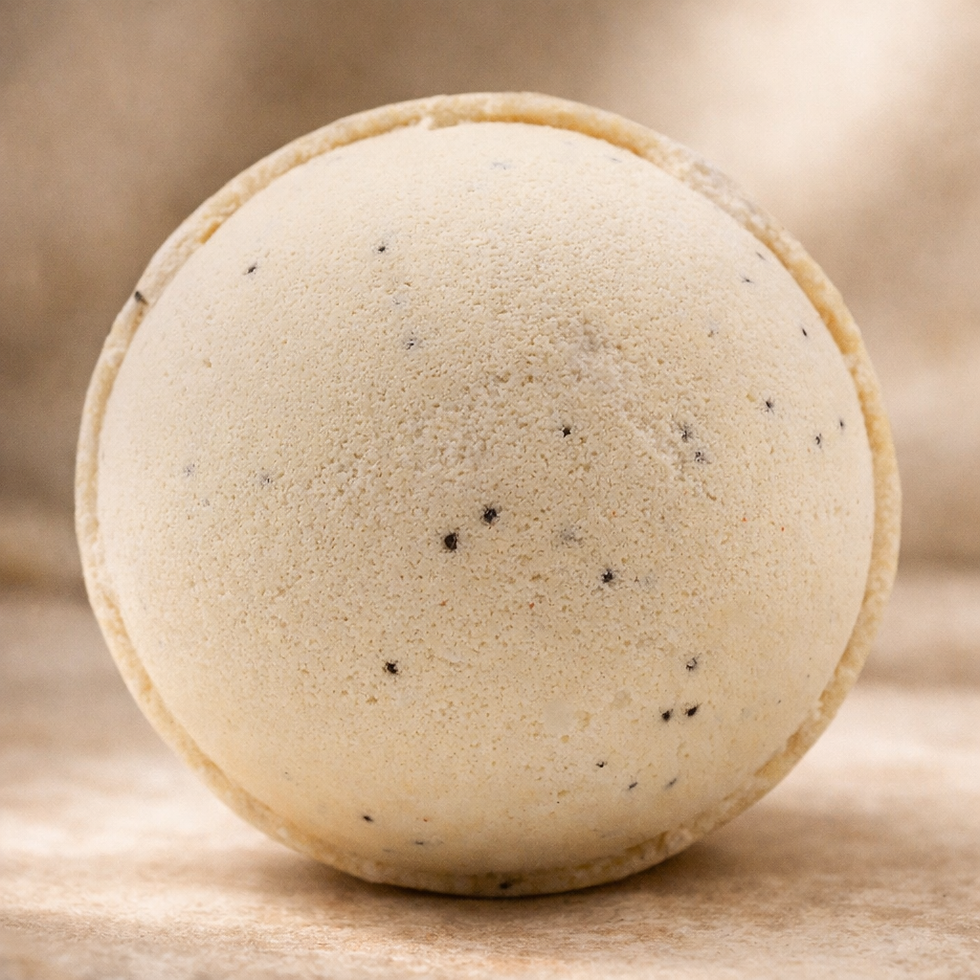 Simply Vanilla scented bath bomb, cream colored with dark vanilla bean specks resting on a neutral background.