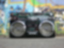 a close up photo of an old school boombox with colorful graffiti behind it