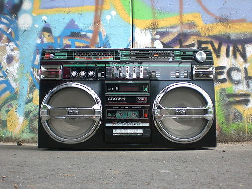 a close up photo of an old school boombox with colorful graffiti behind it
