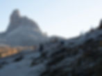 Cyclist and hikers on rocky Dolomites trail below Becco di Mezzodì near Rifugio Palmieri, part of a guided Bike & Hike experience from Cortina.