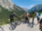 Bike & Hike group on mountain trail, one pointing