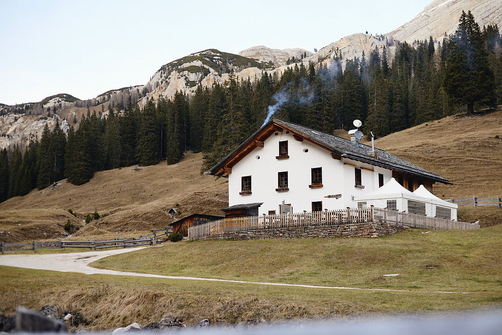 Malga Ra Stua mountain hut surrounded by alpine meadows and pine forests in the Dolomites near Cortina d’Ampezzo.
