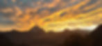 Sunset over Mount Pelmo in the Dolomites, with glowing orange clouds and mountain silhouettes near Rifugio Scotter.