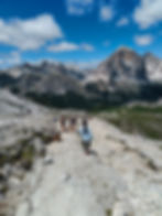 Hikers descending from Nuvolau toward the Tofane peaks in the Dolomites near Cortina d’Ampezzo on a clear summer day.
