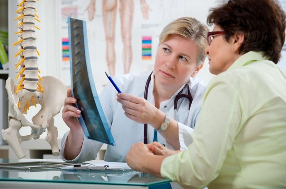 Doctor explains spine X-ray to patient