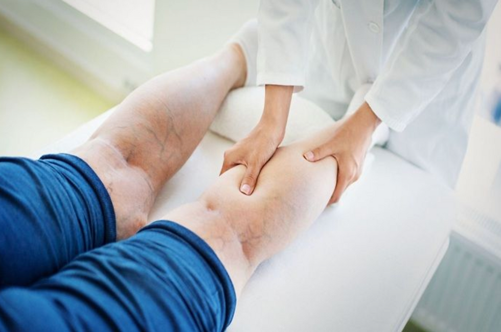 Medical professional examining leg at vein clinic