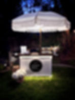 Illuminated Modern Graze cart beneath a white parasol at an evening event