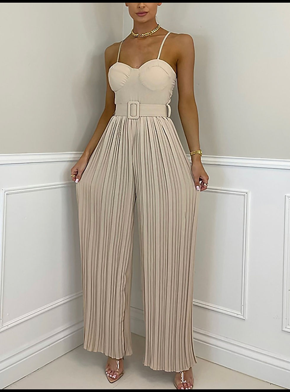 Woman in cream jumpsuit with pleated pants and belt, Madame Curves.
