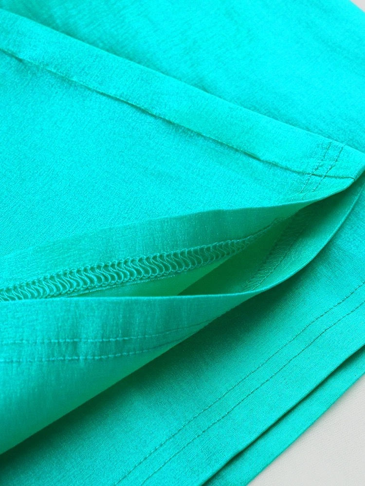 Thumbnail: Close-up of vibrant turquoise fabric with visible stitching and seam detail.