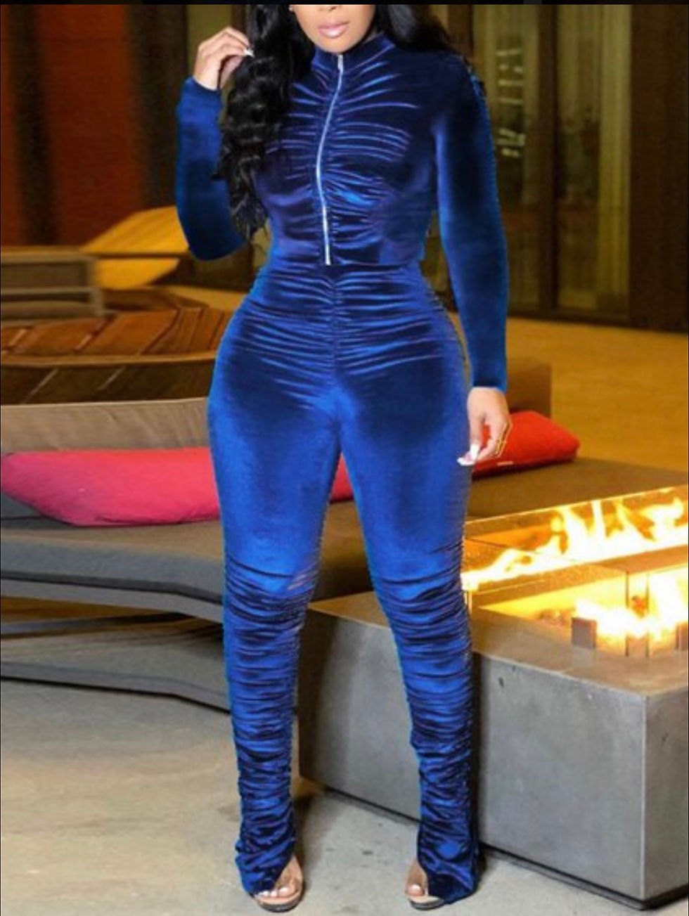 Thumbnail: Woman in blue velvet jumpsuit, posing near fireplace, stylish look. Madame Curves