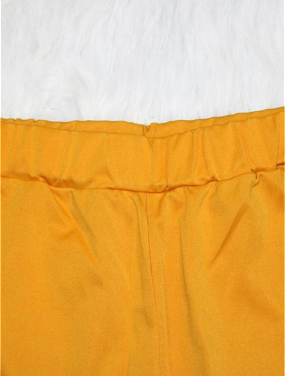 Thumbnail: Bright yellow elastic waistband of pants, white background, close up view.