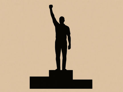 Silhouette of a person standing on a podium with one fist raised in the air, symbolising protest or solidarity, set against a beige background.