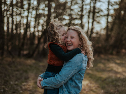 Liefdevolle zussenfoto van een gezinsfotograaf in de Veluwe