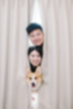 寵物家庭寫真拍攝：一對情侶與柯基犬從窗簾後方探出頭微笑