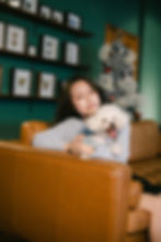 寵物家庭寫真拍攝：女子在沙發上擁抱白色比熊犬