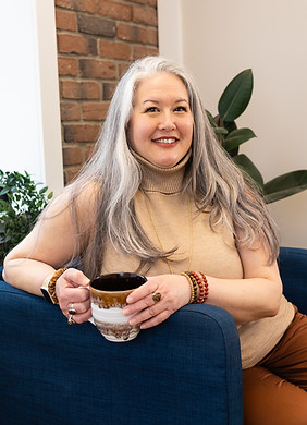 Smiling therapist sitting in a chair in London, Ontario Therapy office