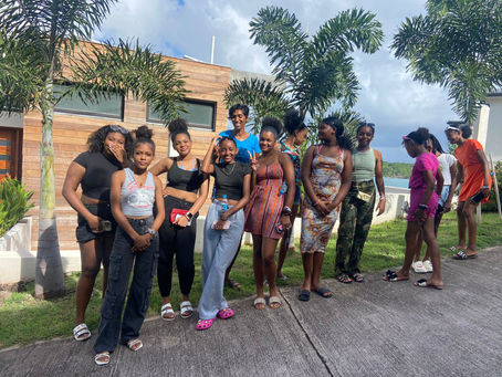 Group of young ladies outside a house with wood facing