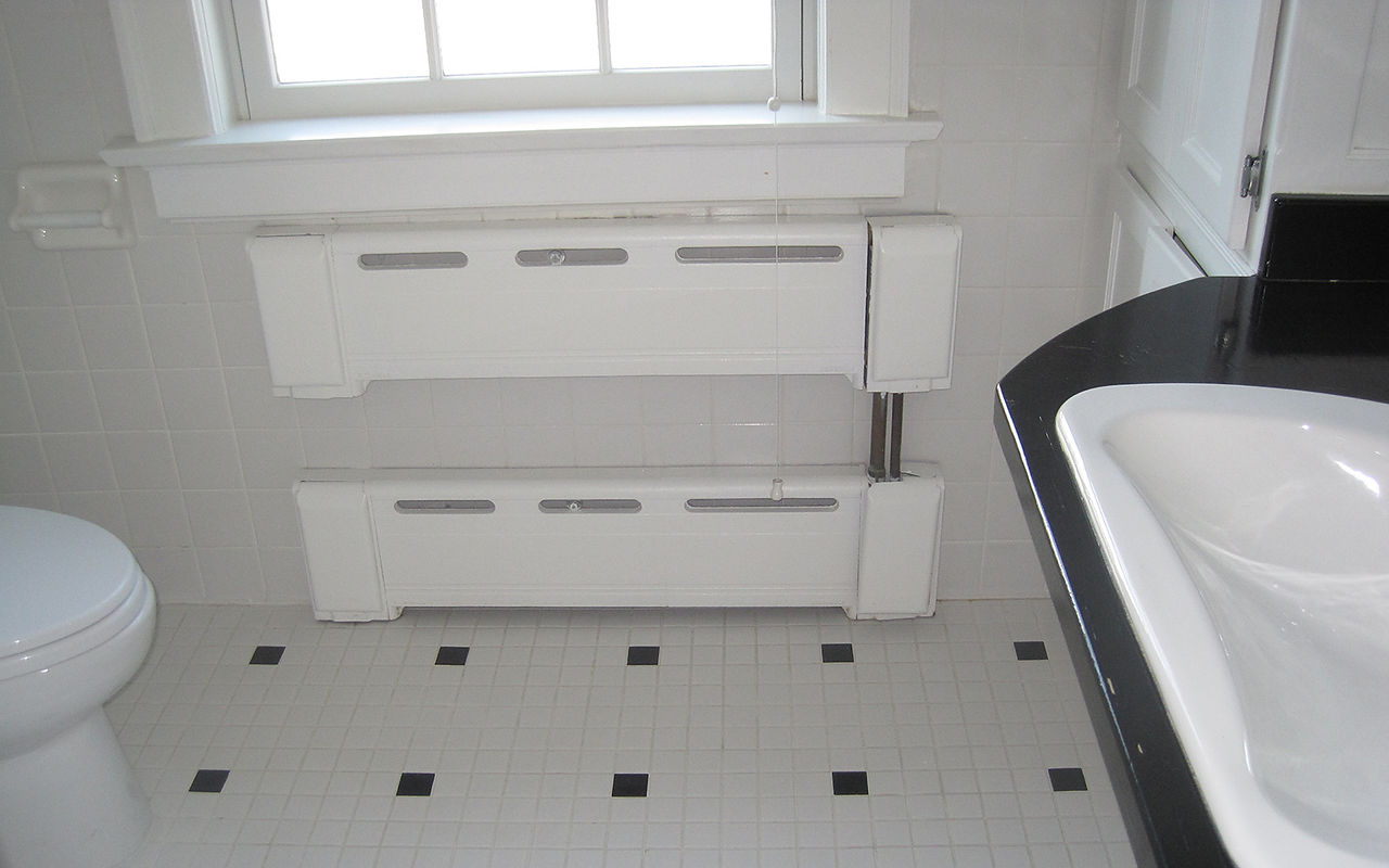White tile with grey accents on floor of bathroom
