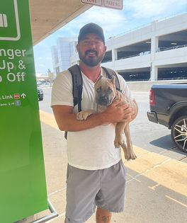 Man holding black puppy