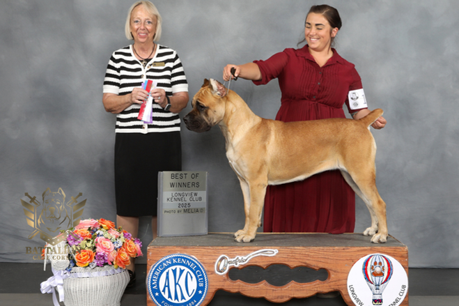 Two women holding a tan dog