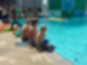 children and youth sitting on the side of the pool