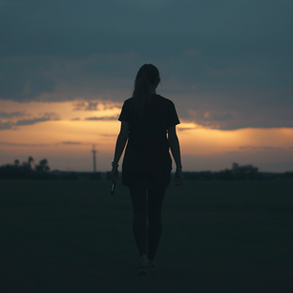 Person walking toward a glowing horizon at dusk, symbolizing quiet progress.