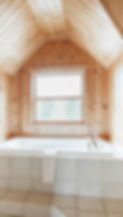 A window set above a huge bathtub set in the wall of a Chalet