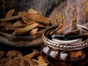 Burning oud incense crafted from agarwood resin, one of the world's most valuable natural fragrance ingredients.