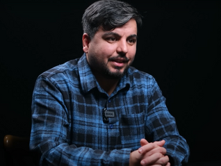 Arif Kocabıyık röportajı sırasında mikrofonla konuşurken.