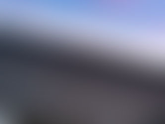 Modern metal roof on a house, with a white facade, under a blue and pink sunset sky. The mood is serene.