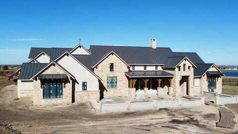 Large newly built house with stone and siding by a lake
