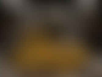 Ein dramatisches 3D-Rendering zeigt einen Wrestlingkampf in einem beleuchteten Ring. Ein großer, kampfgezeichneter Roboter mit dem bekannten, verschlungenen Hexagon-Logo von ChatGPT auf der Brust kniet über einer anthropomorphen Banane mit der Aufschrift „NanoBanana2“. Die Banane liegt am Boden, wirkt angespannt und wehrt sich sichtbar. Der Roboter hält ihren Arm fest und dominiert die Szene. Im Hintergrund feuert eine jubelnde Menge das Geschehen an, mit Schildern wie „GO NANOBANANA!“ links und „FORZA ChatGPT“ rechts. Die Beleuchtung ist hart und kontrastreich, der Boden wirkt schmutzig und abgenutzt, was die intensive Kampfatmosphäre verstärkt.