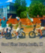 Bikers from GoodVibes Bike Tours enjoy a vibrant photo opportunity in the sunny streets of Austin, TX.