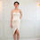 Thumbnail: A short haired lady wearing a beige tube JACQ cockatil dress with side front slit.