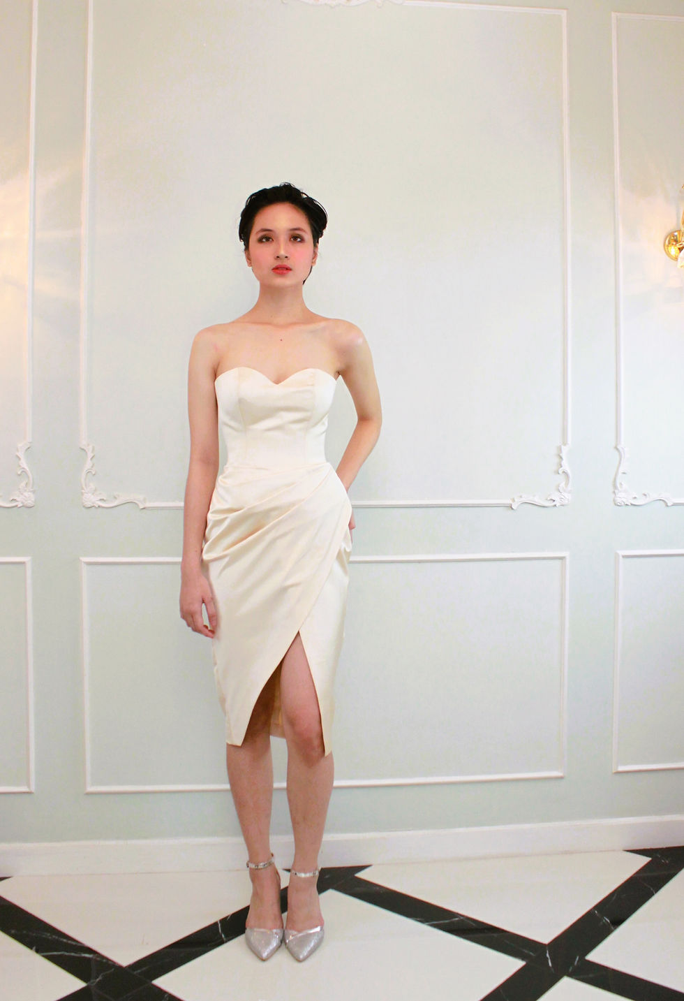 A short haired lady wearing a beige tube JACQ cockatil dress with side front slit.