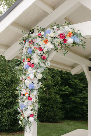 colorful floral arrangement on outdoor ceremony arbor