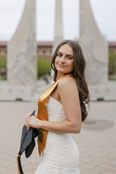 purdue graduate holding hat looking over shoulder