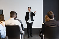 Femme s’exprimant en public avec assurance, symbolisant la gestion du stress et la prise de parole sereine.