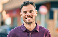 Homme souriant en ville, incarnant la confiance en soi, l’équilibre émotionnel et le bien-être intérieur.