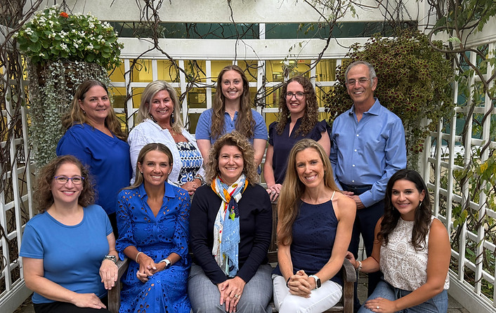 Ten smiling Beacon Pediatric providers posing outdoors.