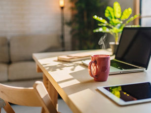 Ein Arbeitsplatz mit Laptop und Tablet in gemütlicher Atmosphäre