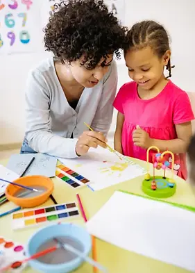 Teacher showing kid how to paint.webp