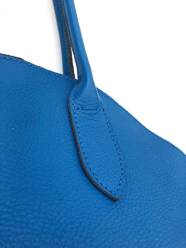 handles of a blue leather weekender bag