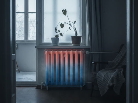 Kış günü loş bir odada, alt kısmı soğuk (mavi) ve üst kısmı sıcak (turuncu) görünen, verimsiz ısınan eski tip bir radyatör.