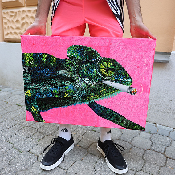 Chamäleon-Gemälde von Künstler Markus Buchsbaum gehalten, der eine kurze Hose in Neon-Pink trägt.