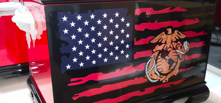 Custom printed vinyl art, displayed in a vehicle shop, of a tattered US flag with a military logo in the center.