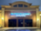 Night view of a halo-lit wall sign above the entryway to a business illuminating the company brand, fabricated by Mello Signs